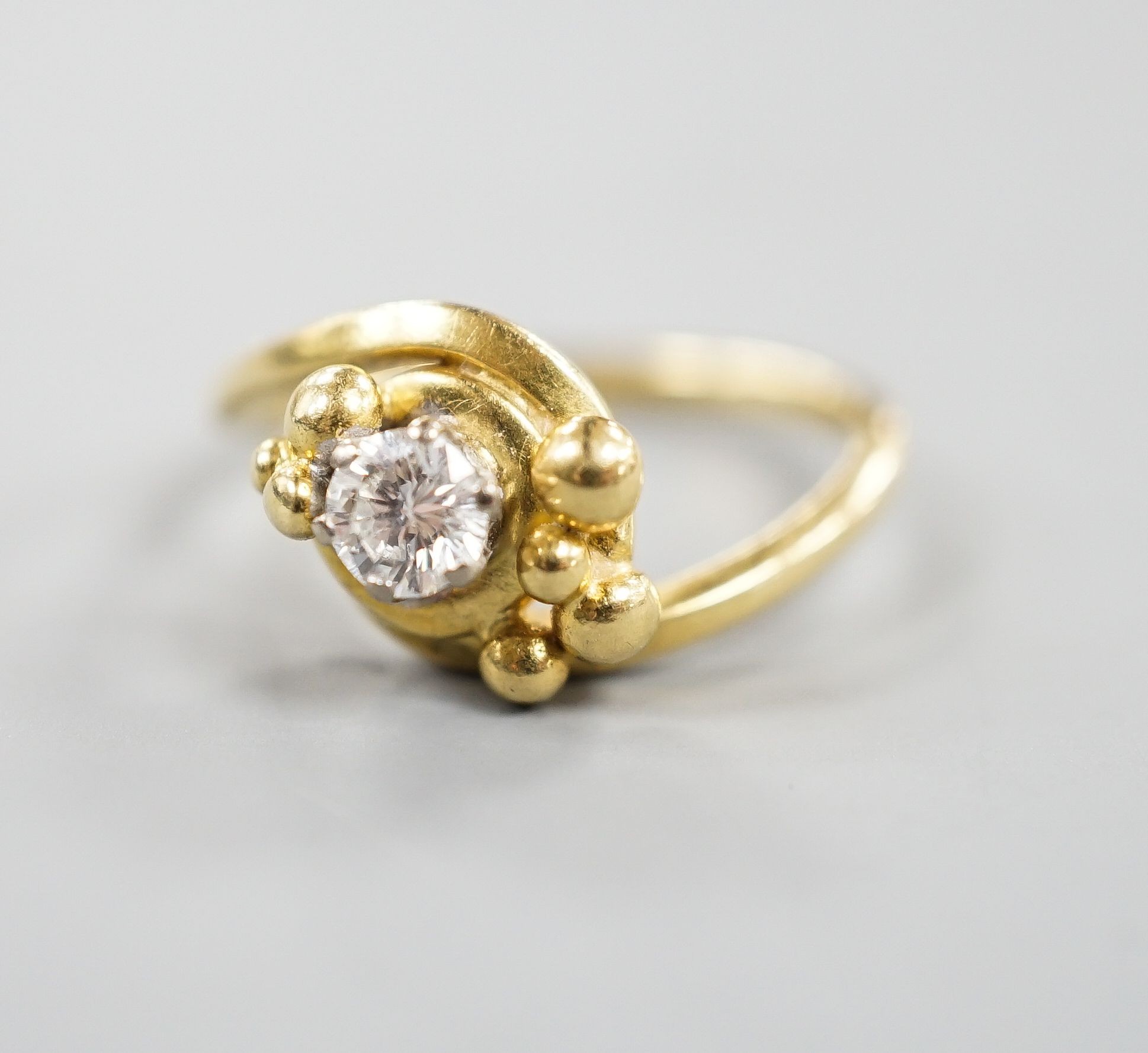 A modern 18ct gold and solitaire diamond ring, in crossover setting, size L, gross weight 3.6 grams.